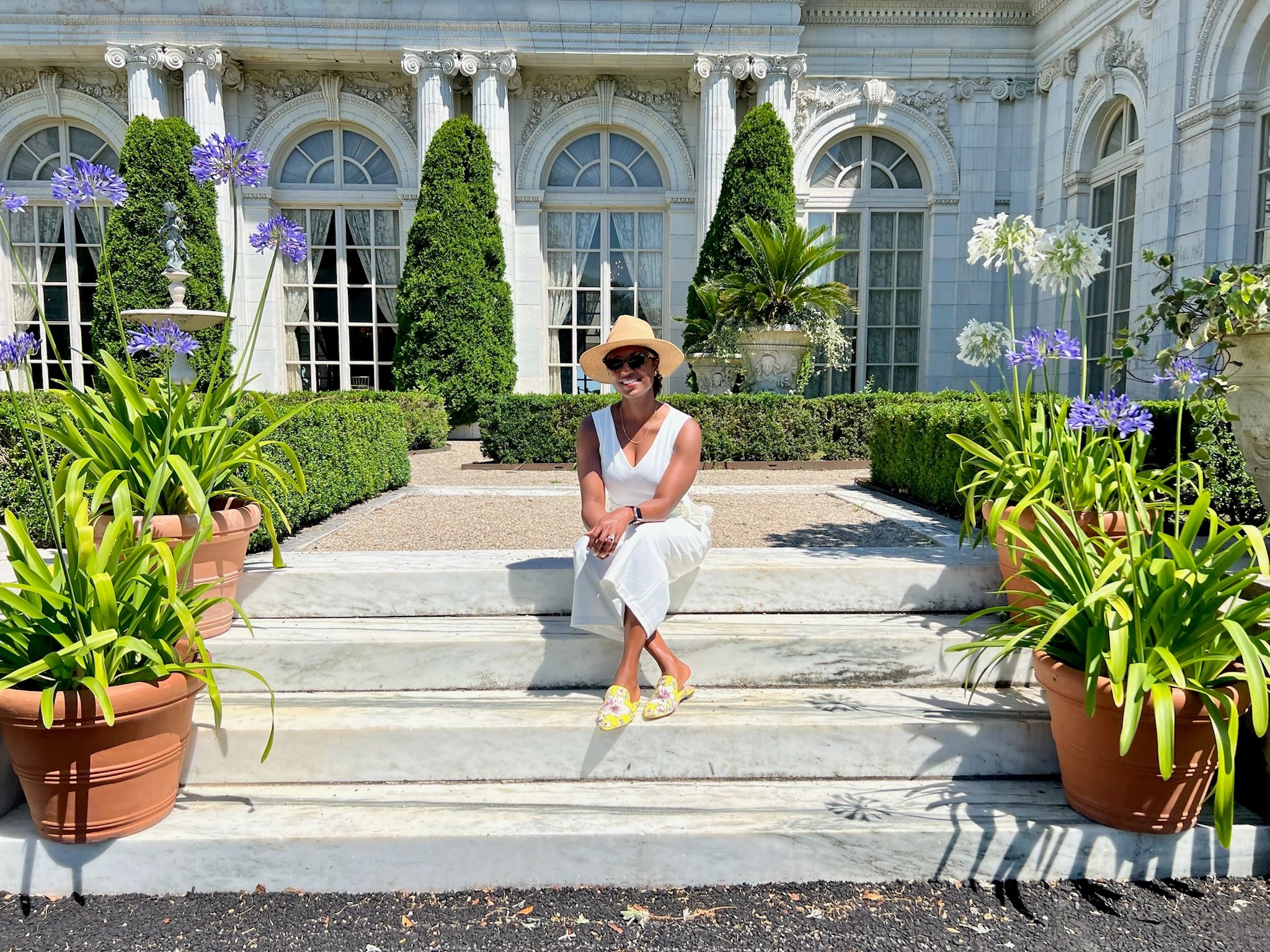 Frocktail founder seated on marble garden steps outside an ornate building